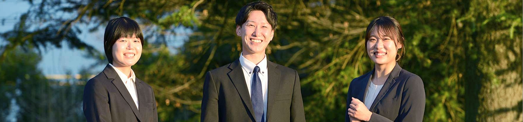 スタッフとスーツ姿の女性が笑顔で対話する社員インタビュー風景